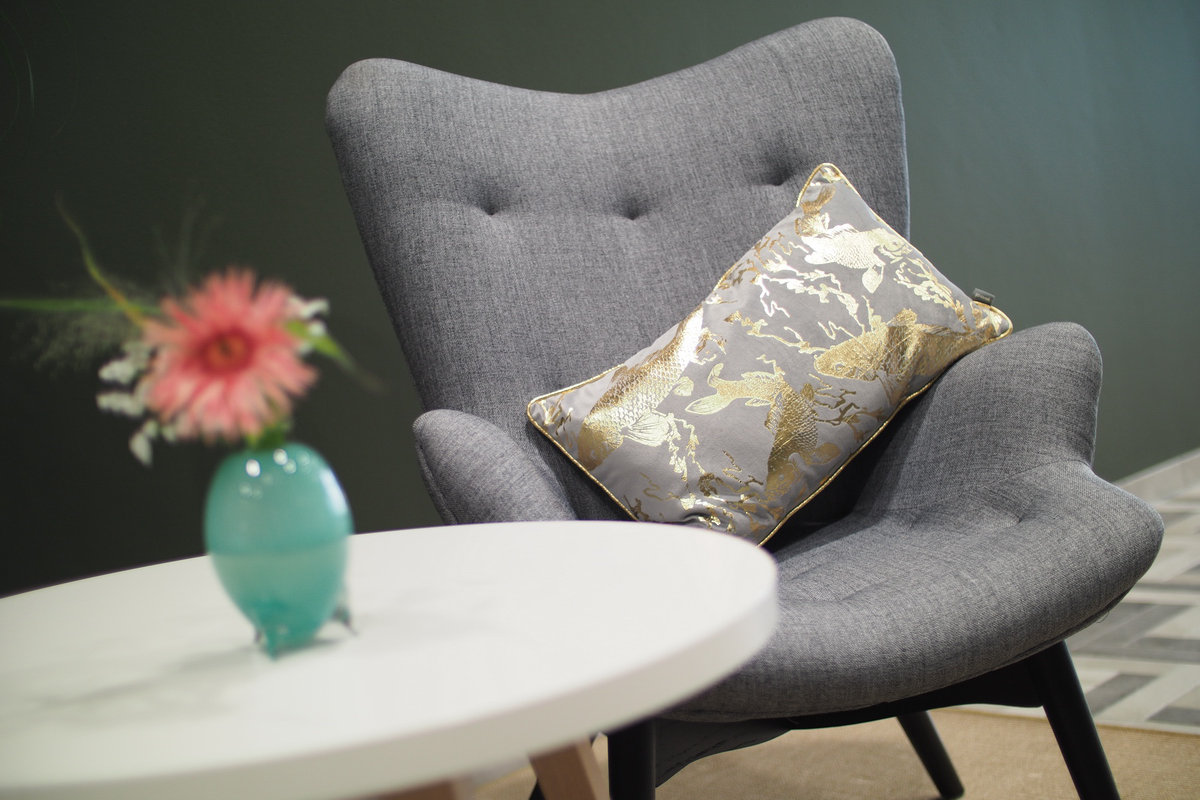 Ein Tisch und ein bequemer Sessel mit Kissen aus unserer Lobby