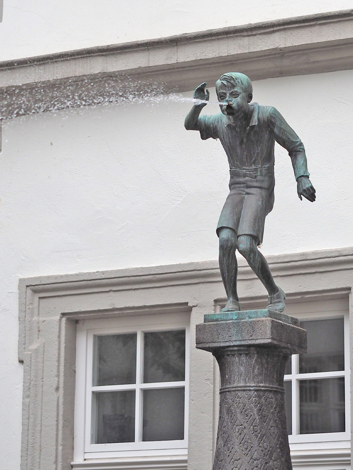 The "Schängelche" is a fountain figure that spits water from its mouth.
